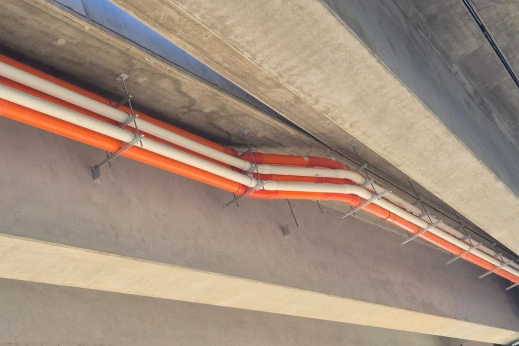 Electrical and communications conduit installation beneath tram overpass Apex Energy Australia electrical and communications conduits installed beneath a concrete tram overpass for Adelaide’s Tram Grade Separation Project.